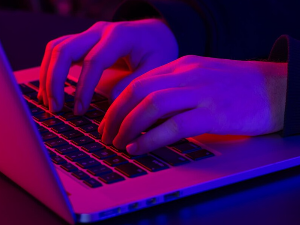 un-uomo-usa-le-mani-maschili-del-primo-piano-del-computer-portatile-nell-illuminazione-al-neon_16901